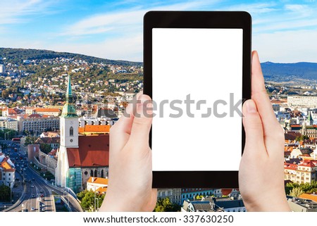 travel concept - tourist photographs Bratislava old town skyline on tablet pc with cut out screen with blank place for advertising logo
