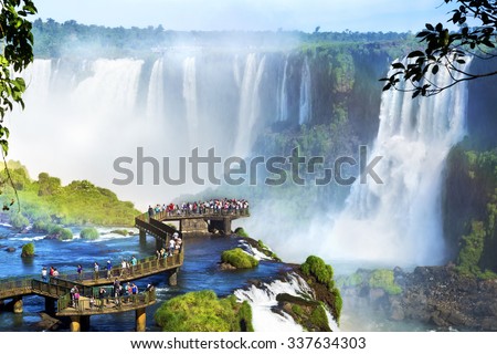Tourists at Iguazu Falls, one of the world's great natural wonders, on the border of Brazil and Argentina. Royalty-Free Stock Photo #337634303