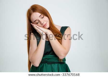 Portrait of a young redhair woman standing and sleeping isolated on a white background