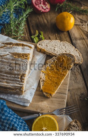 Still life photography, domestic bread spread with homemade bio apricot jam, lots of healthy fruit on dark picture, nice for your advertising