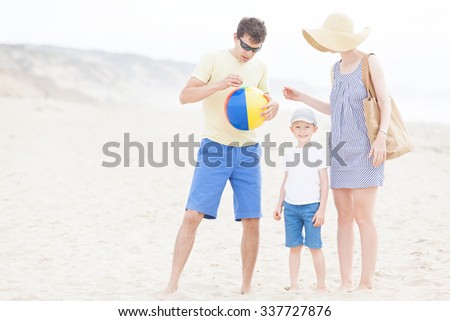 family of three enjoying fun beach activities at the beach in california