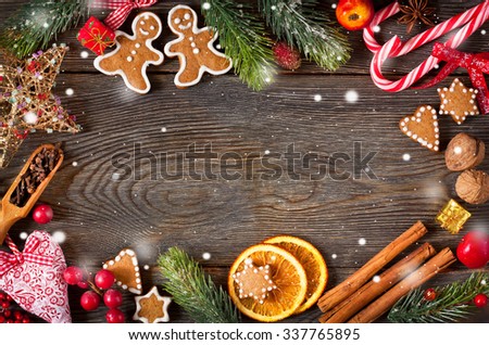 Christmas frame. Gingerbread cookies, spices and decorations on wooden background.