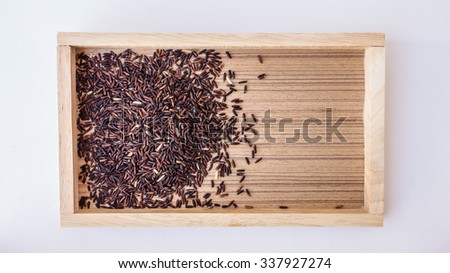 The many black rice seed on the box in white background