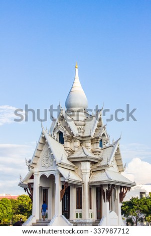 The thailand white temple over water and blue sky