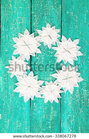 Origami snowflakes on old wooden background