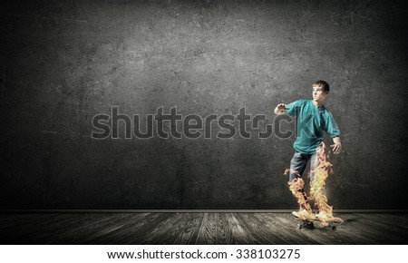 Skater boy riding on his skateboard burning in fire
