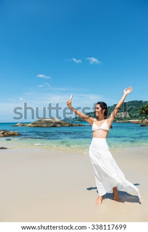 Happy asian girl taking a self portrait photo, selfie on the tropical beach.Copy space