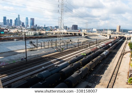Railroad tracks and river viaduct against Los Angeles city background