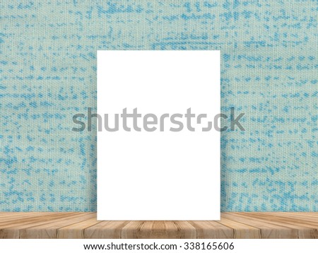 Blank white poster leaning at tropical wood table top with cloth wall,Mock up background for adding your content