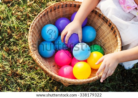 Close-up of a child's hand holding a ball in a ball pool
