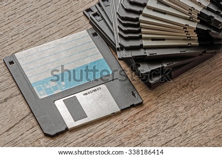 Used floppy diskettes on wooden background.
