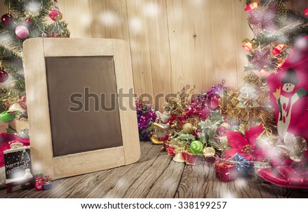 vintage tone image of  Christmas ornaments and Chalkboard on wood background.