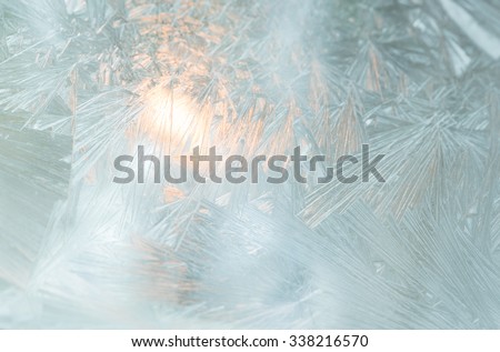 Close up of frosted window with Christmas light inside.