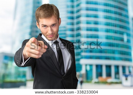 Young handsome businessman pointing on you