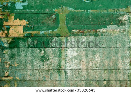 Green surface of the old, semidecayed wall covered with boards