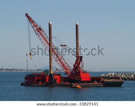 Marine dredge and pile driver sits anchored off of the Taawasan Ferry Terminal near Vancouver, BC.  Point Roberts, Washington can be seen in the background