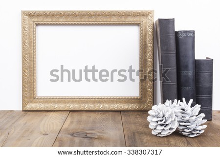 Horizontal Golden Empty Frame With Old Books on Brown Wood Table