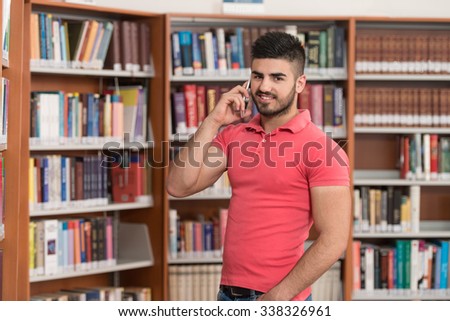 Male Student Talking On The Phone In Library - Shallow Depth Of Field
