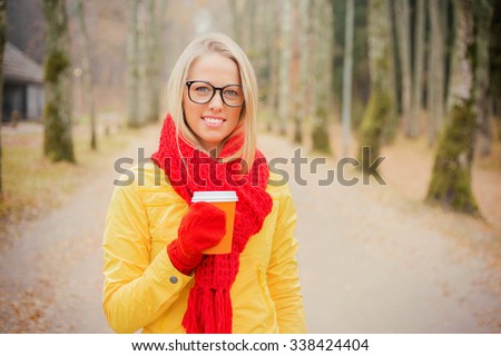 Girl in yellow jacket and red scarf having coffee