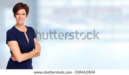 Beautiful young business woman over blue office background.
