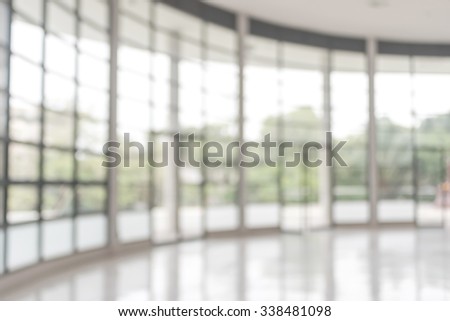 Blur background interior view looking out toward to empty office lobby and entrance doors and glass curtain wall 