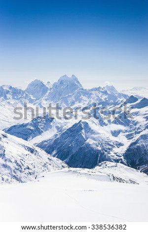 Snowy winter Greater Caucasus mountains with Ushba at sunny day, view from ski slope Elbrus. Kabardino-Balkaria, Russia Royalty-Free Stock Photo #338536382
