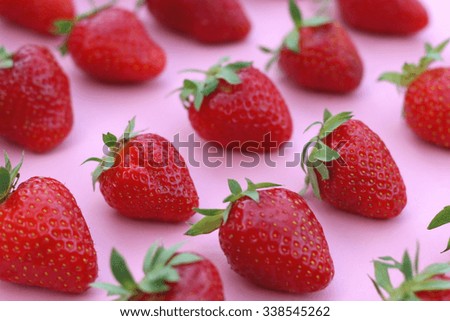 Strawberries organized on pink background. Selective focus.