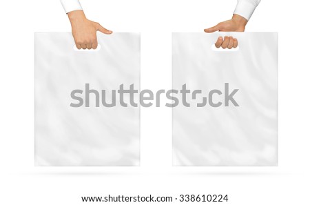 Blank plastic bag mock up holding in hand. Empty polyethylene package mockup hold in hands isolated on white. Pack ready for logo design or mall identity presentation. Food shopping packet handle. Royalty-Free Stock Photo #338610224