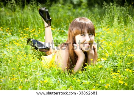 Beautiful young brunette woman relaxing in the grass