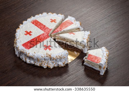The symbol of war and separatism: a cake with a picture of the flag of Georgia country is broken into pieces