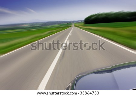 Zooming fast moving car traveling on the road