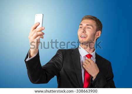 Handsome young businessman taking a selfie with a mobile phone