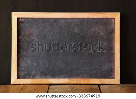 old vintage wooden blackboard on wooden table with space for text 