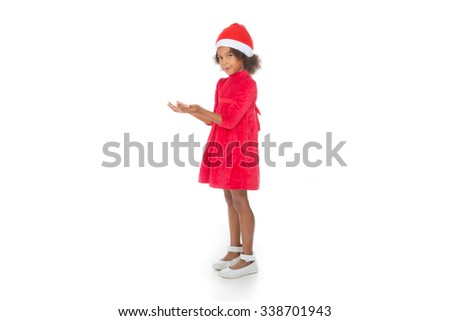 little kid with Christmas dress hold something in her hands