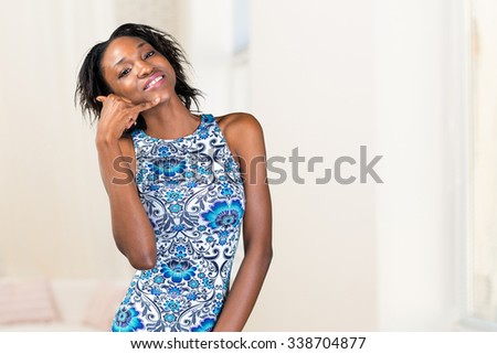 smiling african woman doing call me sign