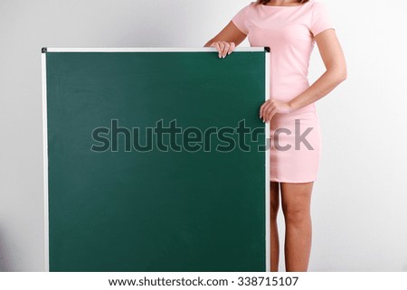 Woman in rosy dress with green blackboard, close up