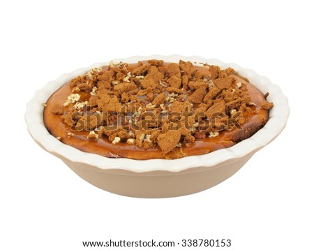 isolated photo of a homemade pumpkin and caramel cheesecake topped with walnuts and crushed ginger bread cookies
