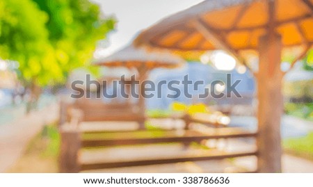 image of blur wooden and leaf thathched hut in garden with bokeh for background usage .
