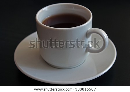 Cup of black tea on gray background