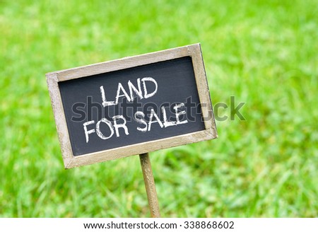 Land for sale - chalkboard with text on green grass background