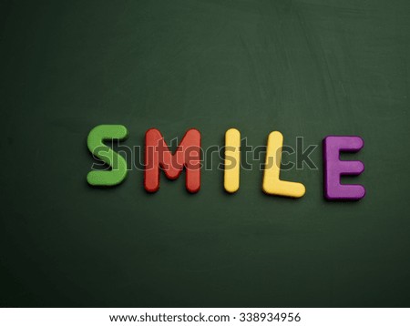 smile concept in colorful letters isolated on blank blackboard