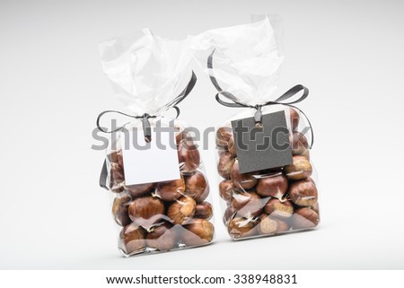 Yin and yang blank sign on twin elegant plastic bags of fresh chestnuts. Shooting on white background in studio.