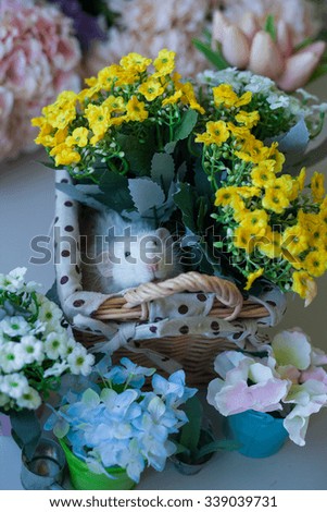 Cute decorative rat on a background of bouquets of flowers