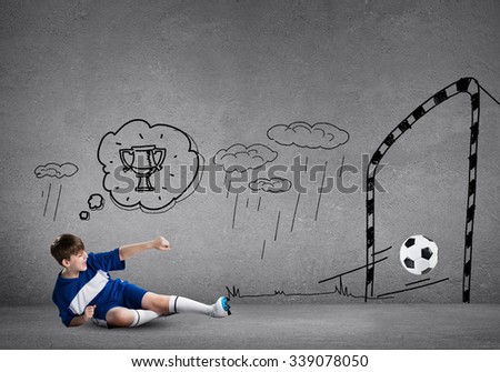 School aged boy on sketched background playing football 