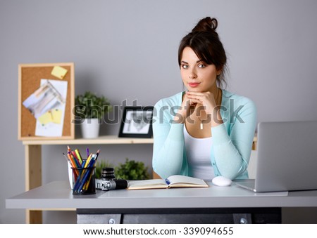 Portrait of  young woman sitting at  desk 