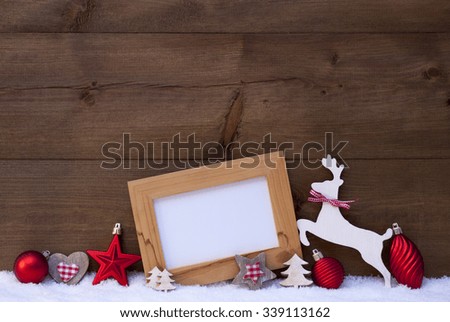 Christmas Card With Picture Frame On Snow. Copy Space For Advertisement. Red Christmas Decoration Like Christmas Ball, Tree, Star And Reindeer. Wooden And Vintage Background