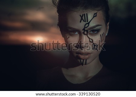 time keeper. watchman. woman with watch on face at sunset. dramatic picture.