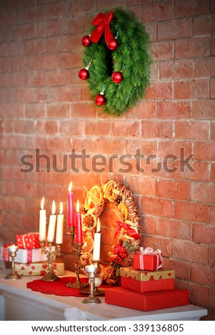 Christmas decorations and candles on mantelpiece  