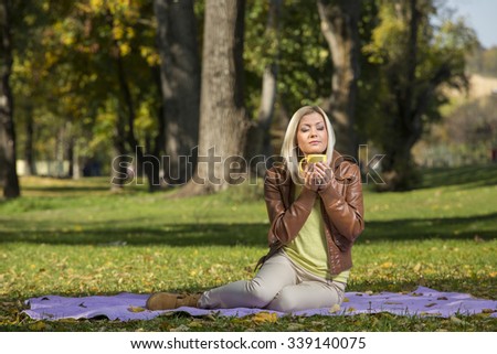 young woman in park drinking tee