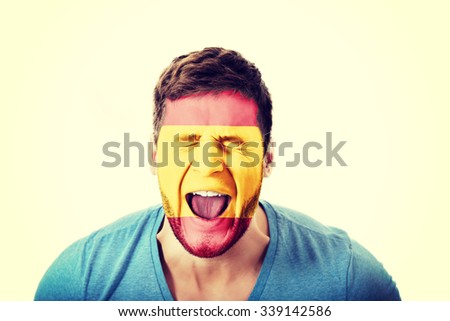 Screaming man with Spain flag painted on face.